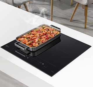 Široki ventilator nalazi se na dva plamenika u indukcijskoj ploči za kuhanje. Hrana u tavi se pari.