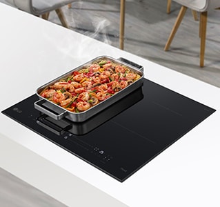 Široki ventilator nalazi se na dva plamenika u indukcijskoj ploči za kuhanje. Hrana u tavi se pari.