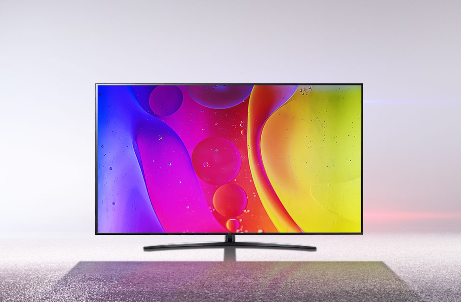 Kar beyazı bir odadaki bir TV ekranı, parlak, hipnotize edici şekilde hareket eden renkleri gösteriyor.