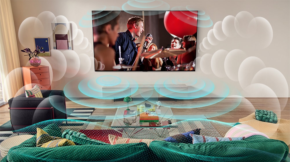 A képen az LG OLED TV látható egy helyiségben, a képernyőn pedig egy koncert. A kijövő buborékok jelképezik, ahogy a virtuális térhatású hang betölti a teret. 