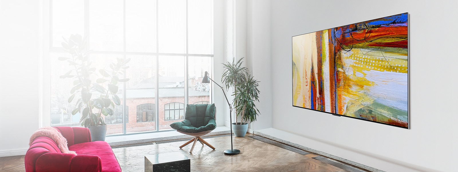 Az LG OLED G3 képe egy színes, absztrakt műalkotást mutat egy élénk színű és napfényes szobában. 
