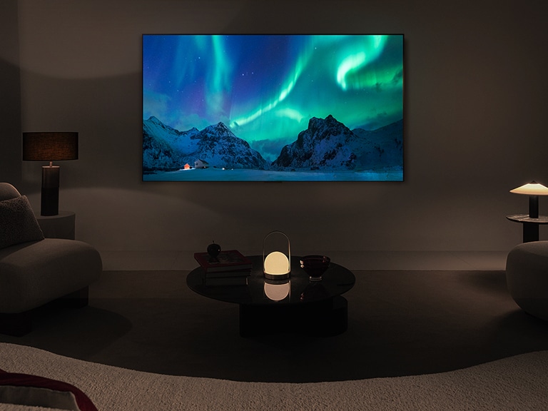 LG OLED TV és LG hangprojektor egy modern nappaliban éjszaka. A sarki fény képe a képernyőn az ideális fényerővel jelenik meg.