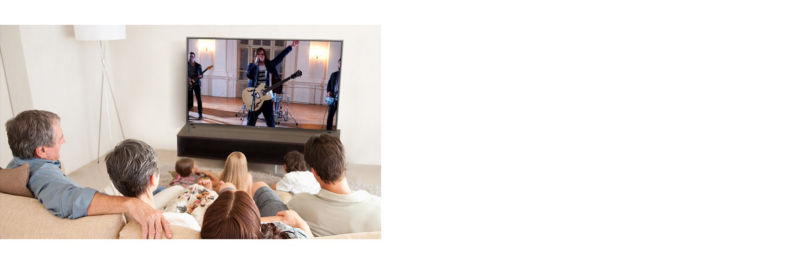 La famiglia di sette membri si riunì in salotto per guardare un film. Una band sta suonando sullo schermo della TV.