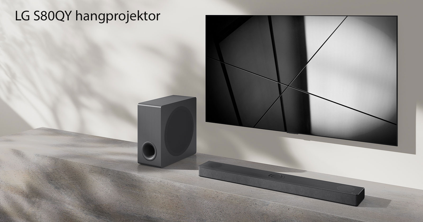 Egy LG S80QY hangprojektor és egy LG TV együtt egy nappaliban. A TV be van kapcsolva, és egy fekete-fehér kép látható rajta.