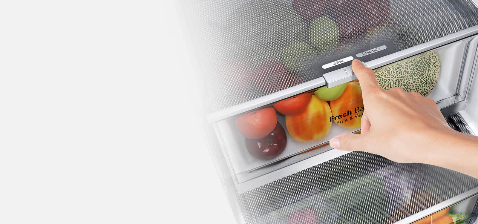 A hűtőszekrény alsó fiókjai tele vannak színes friss élelmiszerekkel. A  kép a szabályozóra fókuszál, amellyel kiválasztható az optimális páratartalom az élelmiszerek frissességének megőrzése érdekében.