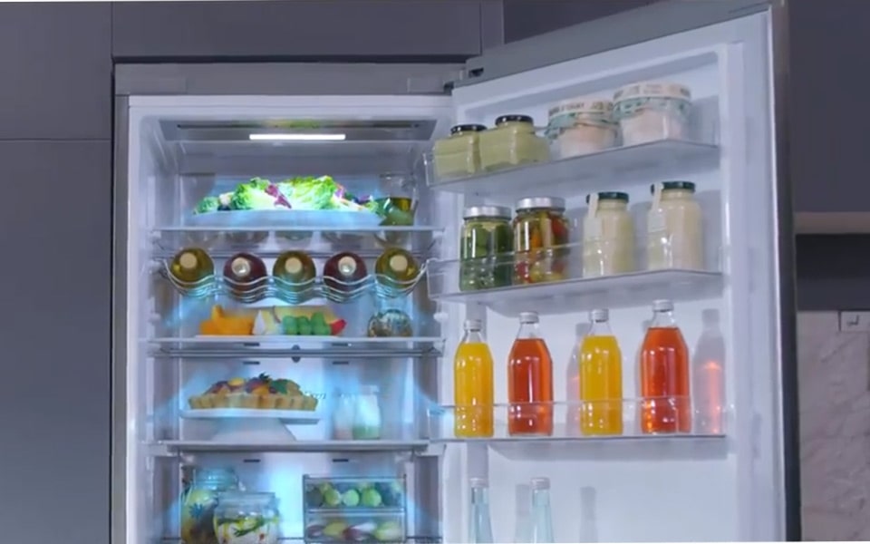 An open LG Refrigerator filled with food and drinks.