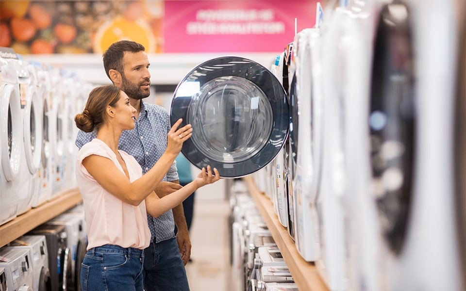 man and woman looking at a washing machine