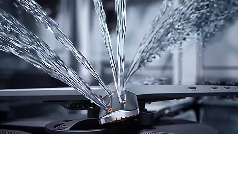 צילום תקריב של זרמי מים חזקים היוצאים מהלהבים המסתובבים של מדיח הכלים.