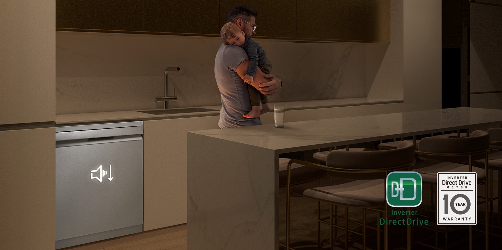 איש מחזיק תינוק ישן במטבח באור עמום, מדיח כלים רצפתי פועל בשקט ברקע.