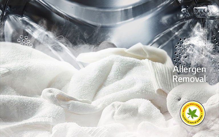 חלוק לבן רך ובובת פרווה מוצגים עם קיטור בתוף של מכונת הכביסה.