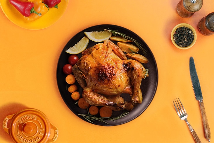 התמונה מציגה צלחת עוף צלוי בתנור שנראה פריך ועסיסי.