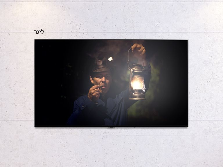 תמונה הניתנת לגלילה של טלוויזיה תלויה על קיר המציגה סצנה אפלה של איש אוחז במנורה. הסצנה מתחלפת בין טלוויזיה בגודל רגיל לבין מסך גדול של טלוויזיית LG QNED MiniLED.