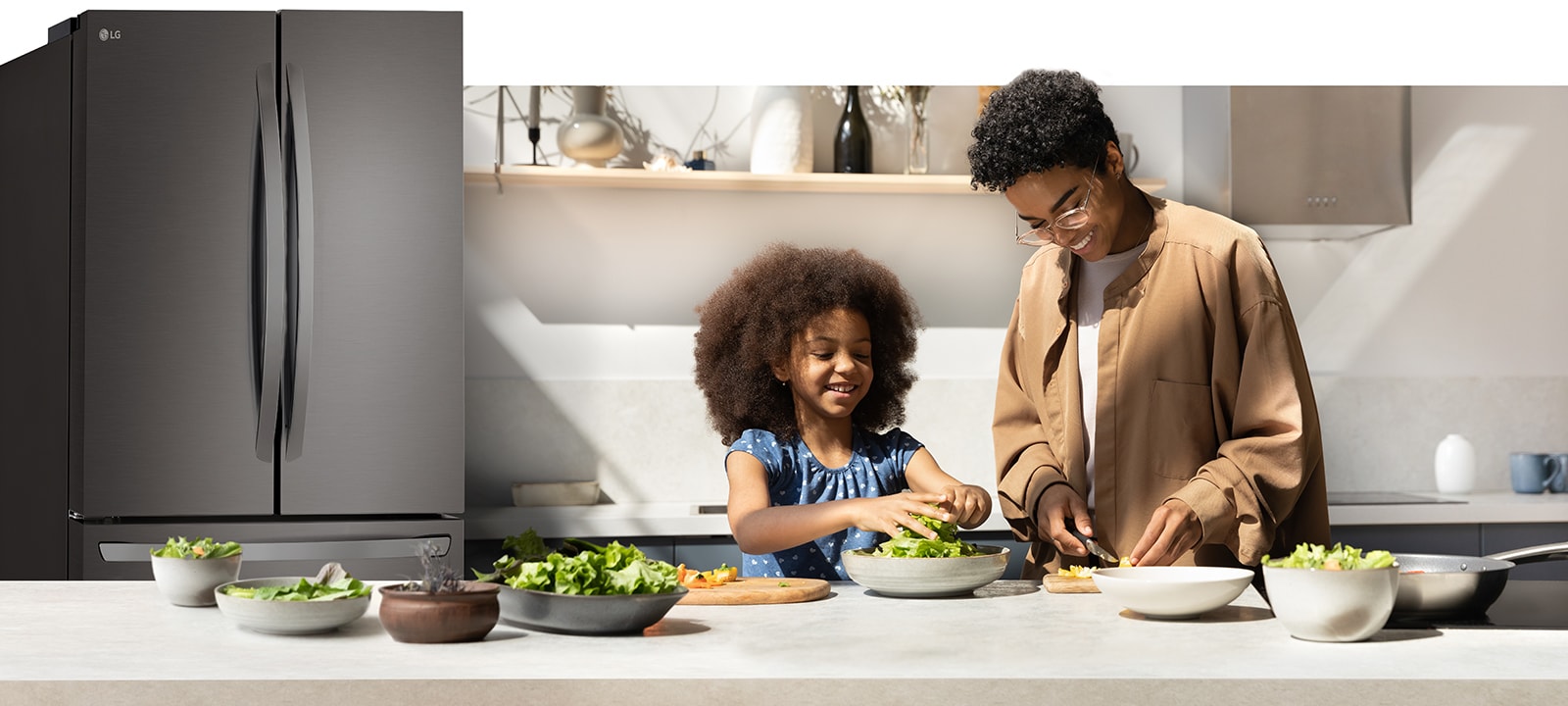 אישה וילדה מבשלות במטבח עם מקרר מואר