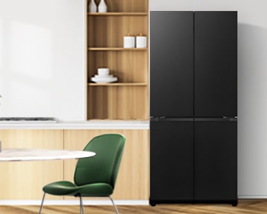 מקרר LG במטבח מעוצב בגוונים חמים עם ארונות עץ וכיסאות ירוקים, למראה טבעי והרמוני.