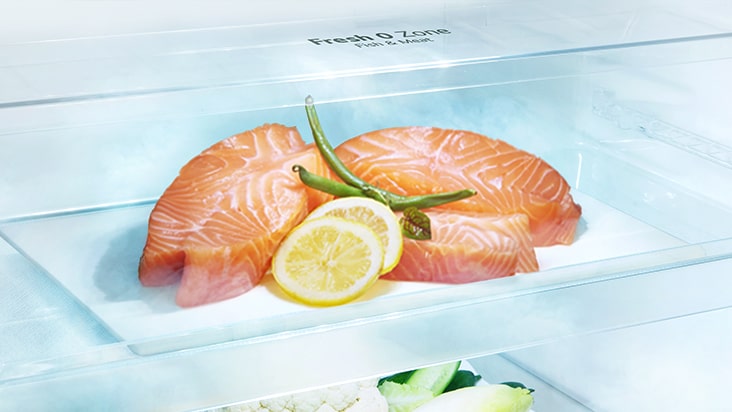מגרת המקפיא בחלק העליון של מקרר LG תוכננה לשמור טוב יותר על מזון כמו בשר ודגים ללא צורך בהקפאה והפשרה, ומציגה חתיכת סלמון עם קישוט של לימון ועשבי תיבול.