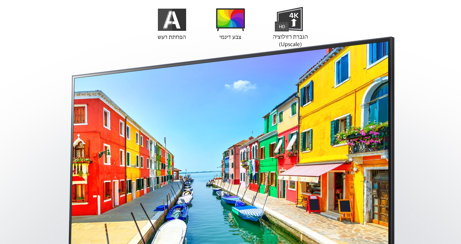 מסך טלוויזיה מציג עיר נמל שבה הבניינים צבועים במספר צבעים וסירות קטנות עוגנות במעגן ארוך וצר. 