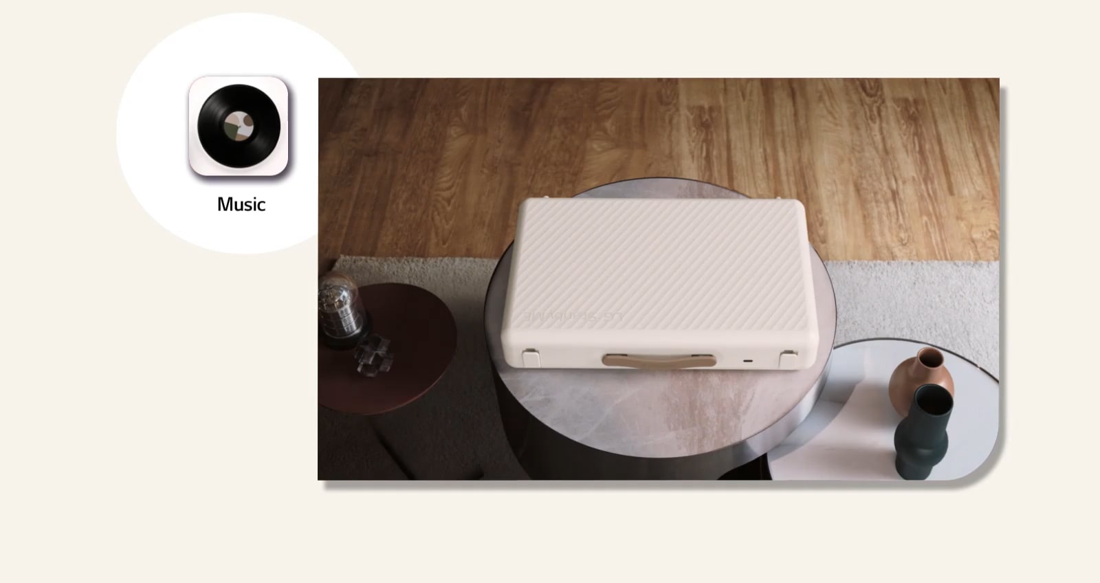 סרטון אנימציה של LG StanbyME Go מונח בסלון. בהתחלה המסך סגור. עם התקרבות המצלמה המסך נפתח והמצלמה מתמקדת מקרוב במסך הבית. המסך מוחלק שמאלה, מחווה עזר מופיע על הסמל 'מוזיקה'. ומראה עטיפת פטיפון ירוקה, והמצלמה מתרחקת. 