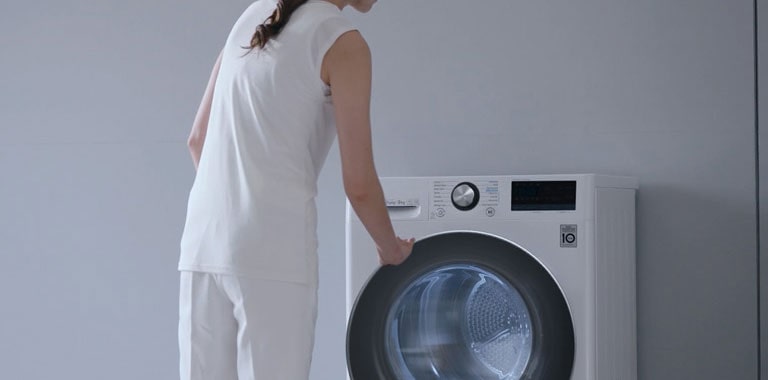 אישה עומדת מול מייבש LG