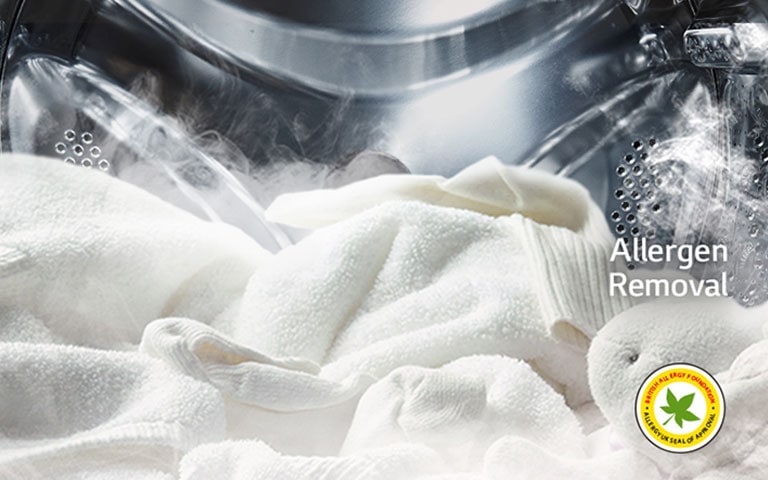 חלוק לבן רך ובובת פרווה מוצגים עם קיטור בתוף של מכונת הכביסה.