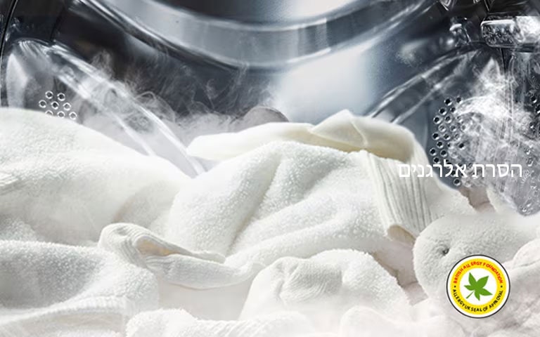 חלוק לבן רך ובובת פרווה מוצגים עם קיטור בתוף של מכונת הכביסה.