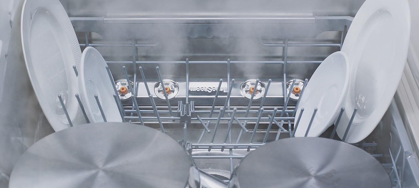 צילומי תקריב של סוגים שונים של כלים נשטפים באדים בתוך מדיח כלים.