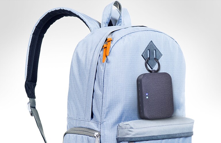 LG XBOOM Go PN1 מחובר לתיק בצבע כחול שמיים.