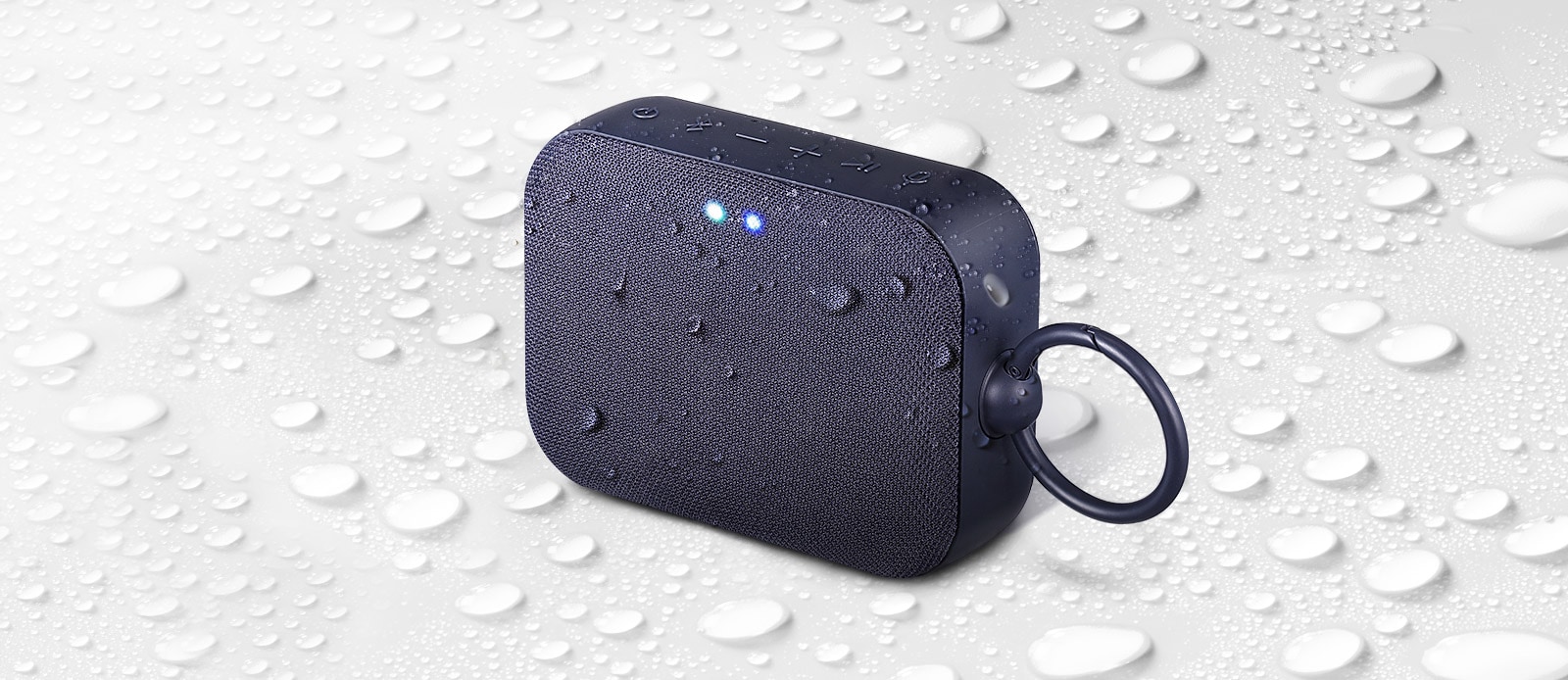 על רקע לבן, LG XBOOM Go PN1 פונה כלפי מעלה לצד שמאל. יש טיפות מים על רמקול LG XBOOM Go PN1 ומתחתיו.