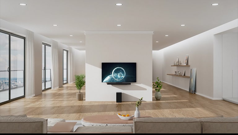 מקרן הקול והטלוויזיה תלויים על עמוד לבן במרכז הסלון. על רצפת העץ, ממש מתחת למקרן הקול, ניצב סאב וופר שחור. בצד שמאל ישנם חלונות מהרצפה עד לתקרה עם נוף יפהפה ווילונות לבנים. בצד ימין ישנם מדפי עץ עם חפצי נוי ותמונה על הרצפה.