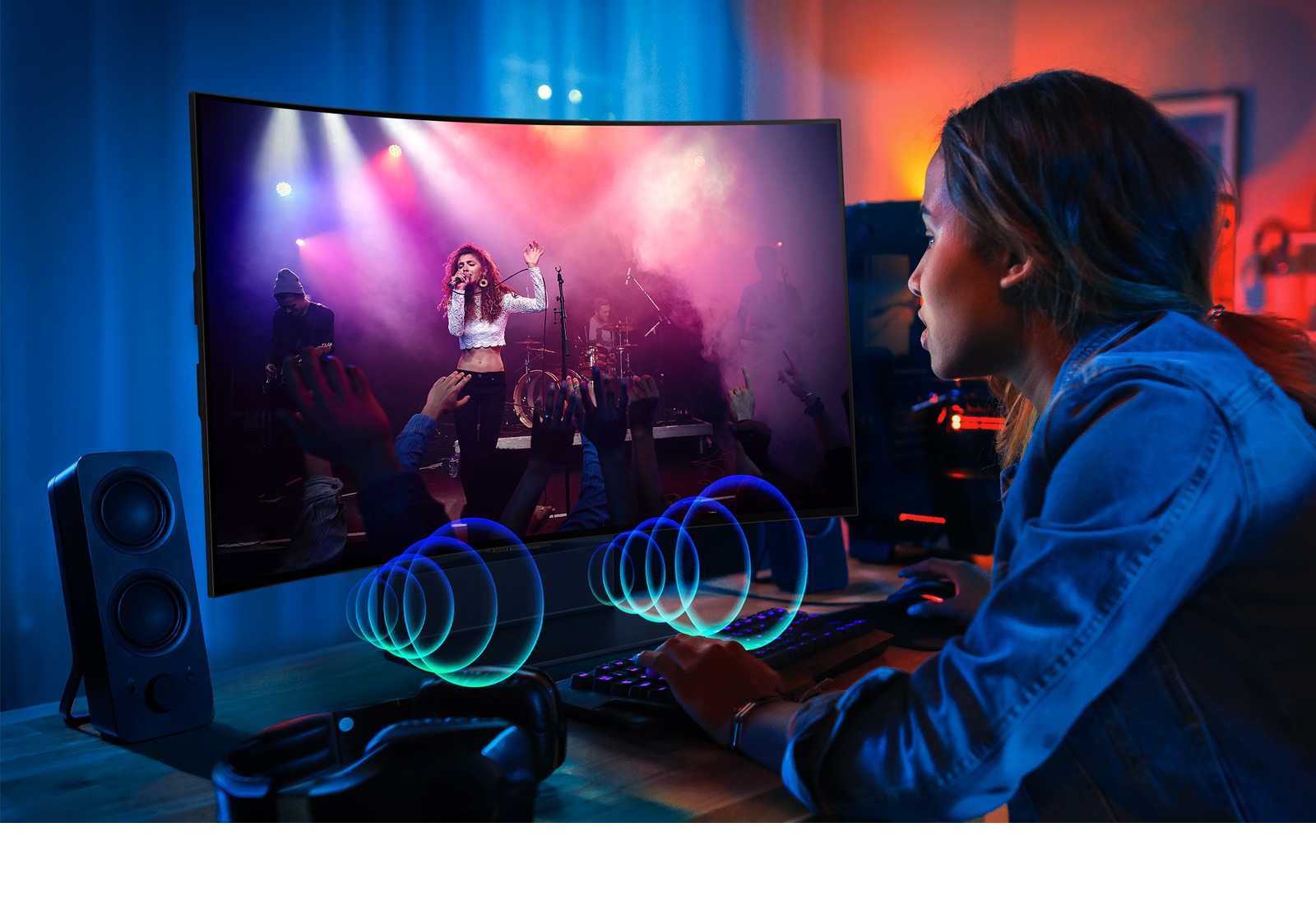 תמונה של אישה צופה בהופעה בטלוויזיית LG OLED Flex. בועות הצליל המוצגות מייצגות את השמע המופק מהחלק הקדמי של הטלוויזיה.