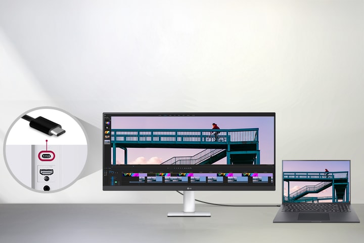 כבל USB Type-C המחובר בין מחשב נייד לצג רחב במיוחד של LG מציג ממשק עריכת וידאו, עם תקריב המראה את יציאת ה-USB-C בגב הצג.
