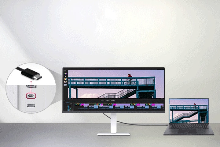 כבל USB Type-C המחובר בין מחשב נייד לצג רחב במיוחד של LG מציג ממשק עריכת וידאו, עם תקריב המראה את יציאת ה-USB-C בגב הצג.
