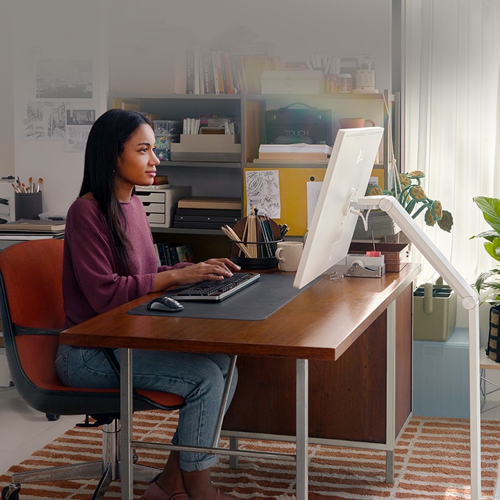 A woman is working using a LG Smart Monitor Swing in this image.