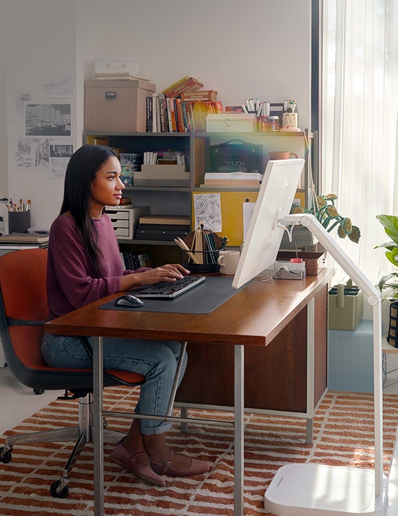 A woman is working using a LG Smart Monitor Swing in this image.