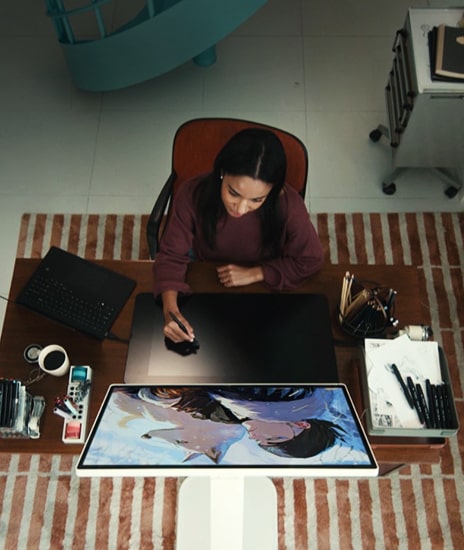 אישה עובדת על איור באמצעות מסך LG Smart Monitor Swing.