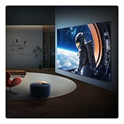 LG טלוויזיה חכמה LG QNED evo AI Mini LED QNED85 4K 2026 100&nbsp;אינץ', טלוויזיית LG QNED evo AI QNED85 Mini LED Ultra Big TV מותקנת על הקיר בחלל מגורים מודרני, ומציגה סצנת אסטרונאוט בקנה מידה גדול על מסך רחב שממלא את החדר באופן חזותי ויוצר נוכחות קולנועית חזקה., 100QNED85B8, thumbnail 16