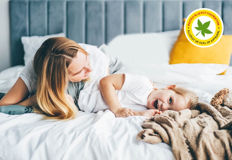 אישה וילד שרועים בנוחות על המיטה, מחייכים בשלווה ובשמחה