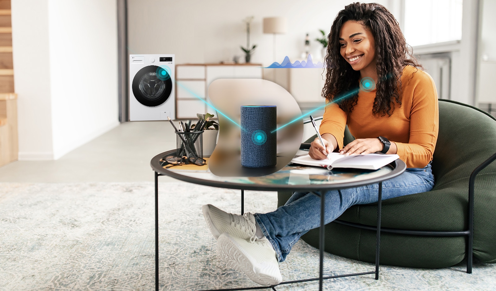 האישה יושבת על הספה, והסמל שמופיע במרכז התמונה מציג רמקול לזיהוי קולי. ברקע התמונה יש מכונת כביסה. קווים מחברים בין מכונת הכביסה, הרמקול שמופיע במרכז, והאישה היושבת על הספה