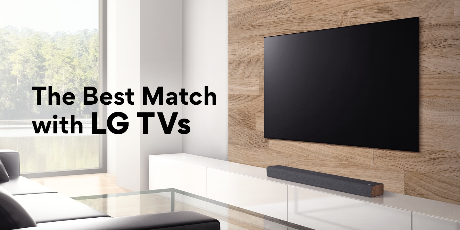 A soundbar is placed on a white TV cabinet and TV is placed on a wooden wall. There is a forest view outisde the window. Text is written on image - The Best Match with LG TVs. 