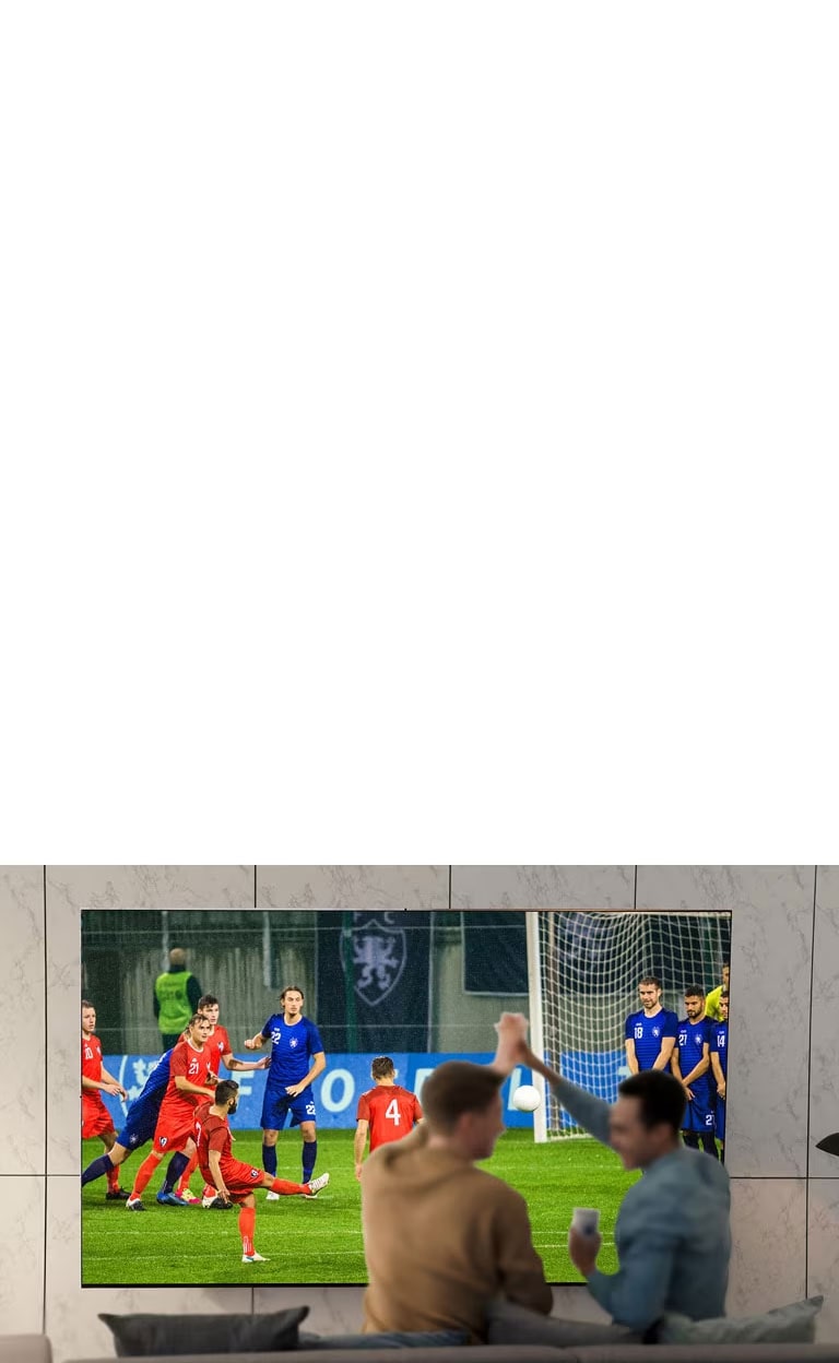 عده‌ای در حال تماشای مسابقات ورزشی در تلویزیون با صفحه نمایش بزرگ در اتاق نشیمن