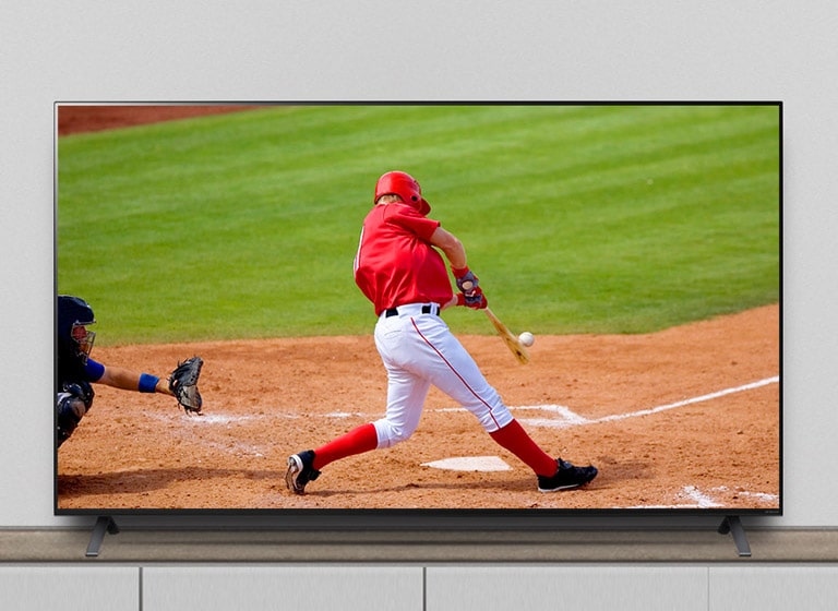 تلویزیون روی پایه قرار دارد و مسابقه بیسبال در حال پخش می‌باشد.