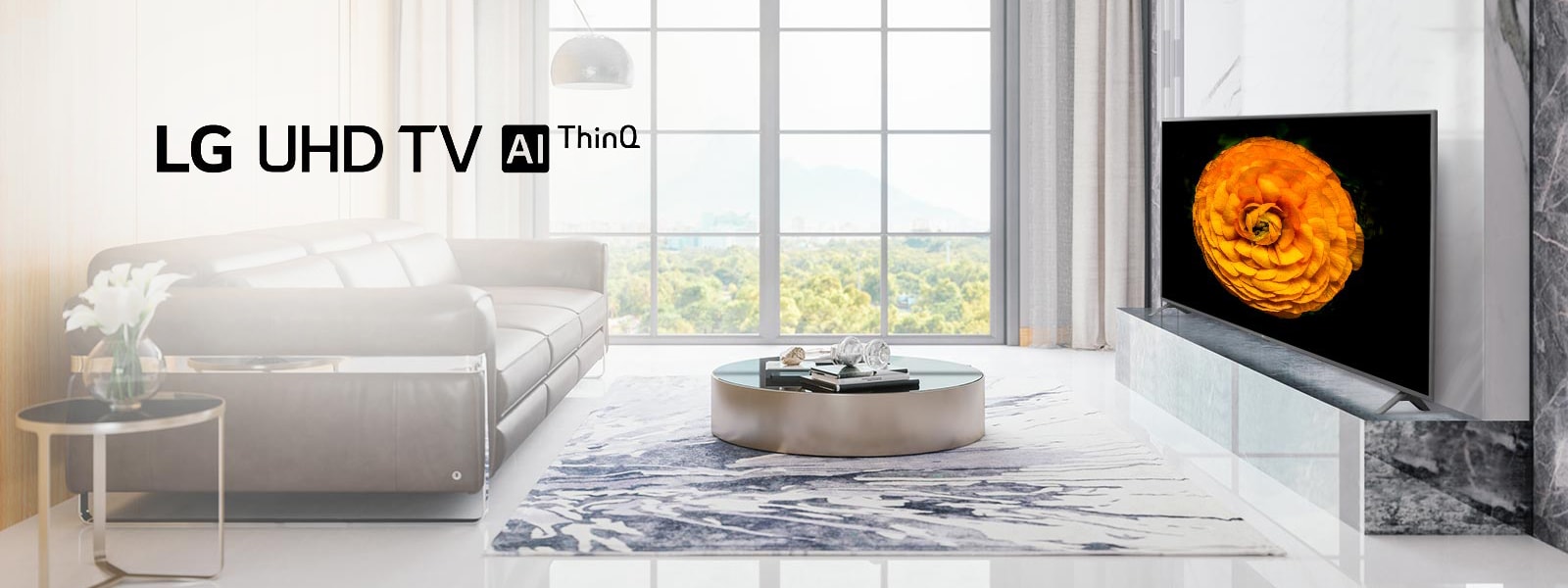 LG UHD TV, located on the wall in a living room with the minimal interior. Image of a flower is shown on the TV screen.