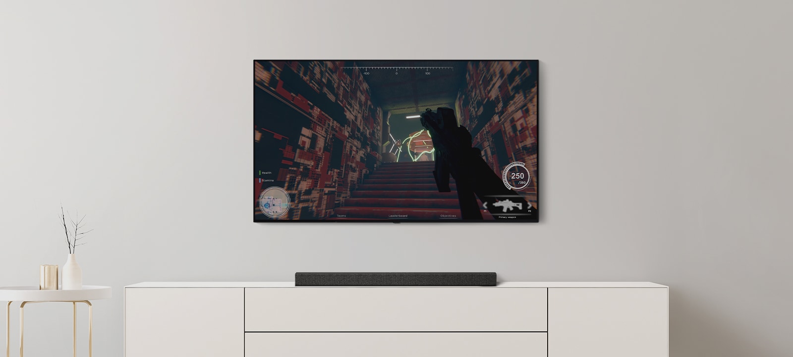 یک تلویزیون و ساندبار در اتاق نشیمن مشاهده می‌شوند. یک بازی FPS در صفحه نمایش تلویزیون در جریان است و کانال تلویزیون به یک مسابقه فوتبال تغییر می‌کند. (ویدئو را پخش کنید)