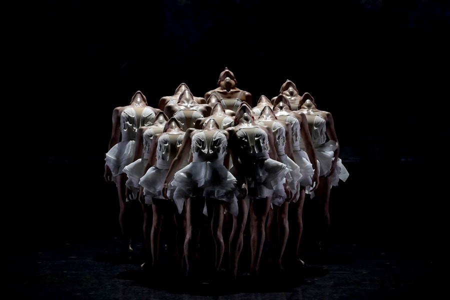 Una foto di ballerine sul palco con le teste inclinate all’indietro.