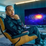 Anteprima di Lewis Hamilton seduto davanti a un TV OLED 8K LG SIGNATURE.