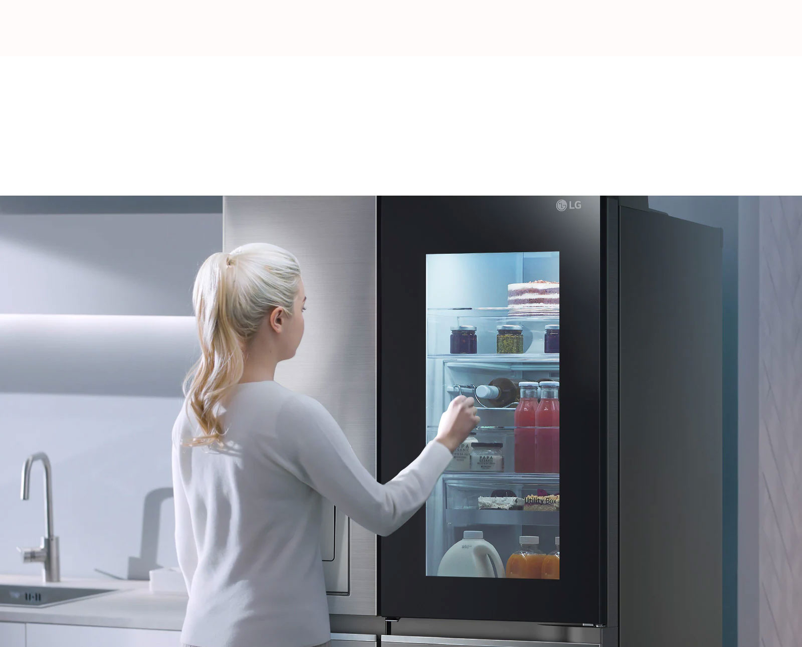 يُظهر مقطع فيديو امرأة تقترب من ثلاجة InstaView وتنقر مرتين. يضيء الجزء الداخلي ويمكنها رؤية محتويات الثلاجة دون فتح الباب.