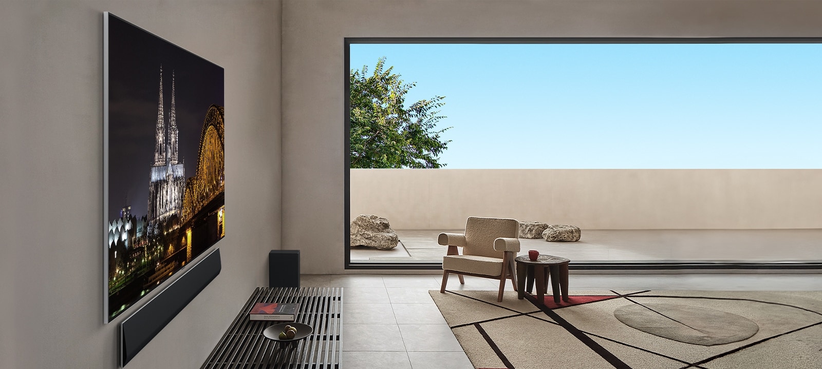 غرفة معيشة تحتوي على تلفزيون LG OLED G5 TV مُثبت على الحائط مع مكبر الصوت LG Soundbar، تُعرض من زاوية جانبية تبرز تصميم One Wall Design وكيف أن الحواف والتصميم ينسجمان بانسيابية مع الحائط. 