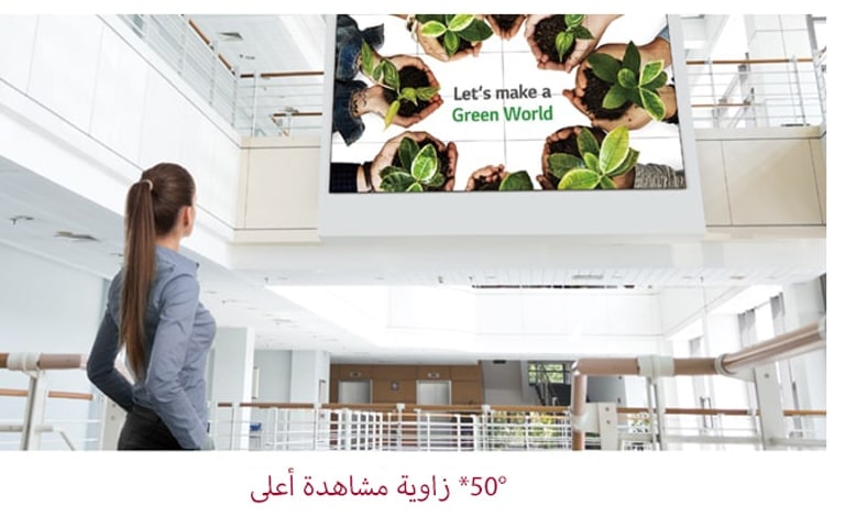 امرأة تنظر إلى الشاشة المثبتة في الطابق العلوي.