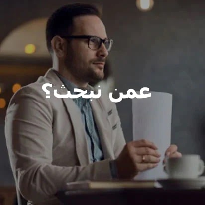 رجل يجلس على مكتب ممسكًا بحزمة من الأوراق