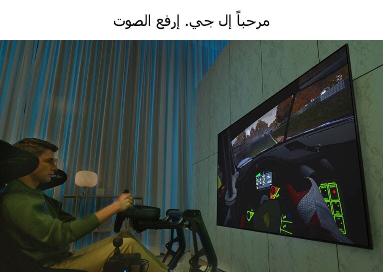 رجل يجلس على مقعد السباق أمام تلفزيون كبير يلعب لعبة السباق.