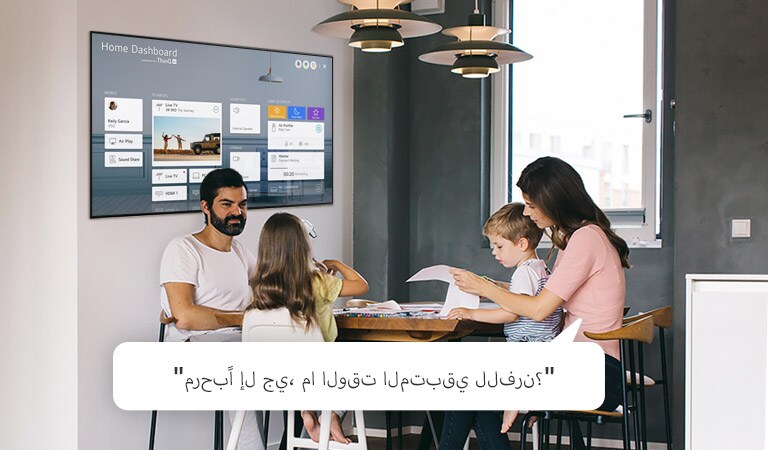 عائلة تجلس على طاولة مع الوالدة تطلب من التلفزيون إخبارها بالوقت المتبقي للفرن